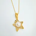Detailaufnahme einer vergoldeten Stern-Halskette mit Zirkonia-Besatz und einer Perle. - Anhänger-Gold (Künstliche Perle) (Ohne Kette)