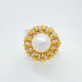 Vista dettagliata dell'elegante anello di perle dorate con pietre a baguette brillanti. - Anello / Perla in Acrilico da 9mm / Oro