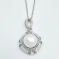 Detailed shot of exquisite silver pearl pendant necklace with sparkling cubic zirconia halo. - Pendant / Acrylic Bead (11mm) / Silver
