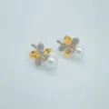 Detailaufnahme von Perlen-Ohrringen im Blatt-Design, vergoldet und mit feinem Zirkonia besetzt. - Ahornblatt-Ohrstecker (Künstliche Perle 9mm)