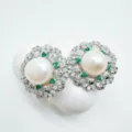 Dettaglio di gioielli con perle e smeraldi con diamanti scintillanti posati su pietra bianca. - Orecchini - Argento (Perla acrilica)