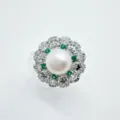 Primo piano dettagliato dell'anello di perle vintage con pietre verdi e zirconi splendenti. - Argento (Perla Acrilica)