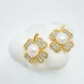 Close-up of elegant gold clover pearl earrings with sparkling zircon crystals on white display. - Clover - Acrylic Beads