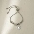 Detalle en primer plano de pulsera de cadena deslizante de acero inoxidable con cruz brillante. - Plata Cruz