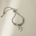 Primer plano detallado de una pulsera deslizante plateada con colgante de ballena y cadena. - Ballena Plateada