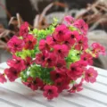 Primo piano di un mazzo di fiori artificiali viola con foglie verdi per decorazione. - Rosso rosa