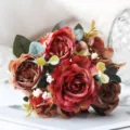 Dettaglio in primo piano del bouquet di rose artificiali vintage con foglie di eucalipto. - Giallo arancio
