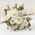 Vista dettagliata di un elegante bouquet di rose artificiali in seta bianca con foglie d'arredo. - Crema