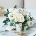 Close-up detail of elegant white artificial flower bouquet with roses and green leaves. - Cream