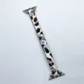 Gros plan sur le bracelet de montre en cuir léopard avec des rivets métalliques et attaches. - Léopard Brun