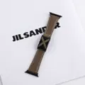 Close-up detail of the premium leather watch strap featuring unique metal X-shaped buckle. - Brown
