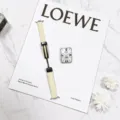 Detail shot of beige leather watch strap with black magnetic folding buckle on a fashion magazine. - 14mm / Off White