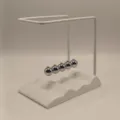 Closeup of the creative wave base Newton cradle with metal balls for desk decor gift. - White