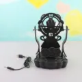 Dispositivo agitatore per cellulare nero con design meccanico e cavo USB per contapassi quotidiano. - Alimentato via USB / Wukong