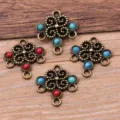 Close-up detail of vintage bronze alloy floral multi-hole jewelry connectors with colorful resin. - Antique Bronze - Mixed Colors