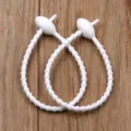 Silicone cable ties detail shot, white reusable elastic strap with oval head for neat organization. - White