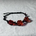Detailopname van handgemaakte macrame zwarte koord kristal edelsteen armband, elegant. - Granaatrood
