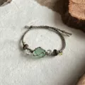 Hand-woven macrame bracelet featuring a wrapped green crystal stone and beads detail shot - Wood Whisper Emerald Rope Bracelet (1 Piece)