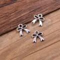 Close up view of three silver alloy bow charms, perfect for DIY jewelry and crafts making. - Bow Connector (22I3-1) / 9x11mm / Antique Silver