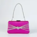 Detailaufnahme der pinken Satin-Abendtasche mit glänzenden Strassketten und Knotendesign. - Fuchsia