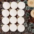 Detalle de adorno de bola de Navidad flocada blanca con piñas y fondo de madera. - 6cm / Juego de 12 / Blanco Roto