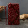 Red embossed leather long wallet with wrist strap and zip-around closure, vintage floral style. - Burgundy