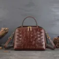 Vintage brown genuine leather dumpling handbag with geometric embossed pattern and crossbody strap. - Coffee