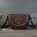 Dark brown genuine leather saddle bag with vintage metal rivets and center gemstone decor. - Coffee