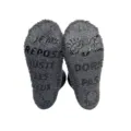 Detail view of dark gray fuzzy winter sleep socks with funny French anti-slip grip text soles. - Black