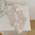 Chaussettes mi-hautes pour femmes en mélange rose avec revers blancs et écusson brodé délicat. - Taille unique / Étiquette en dentelle