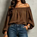 Close-up detail of the elegant off-the-shoulder brown long sleeve top with textured fabric. - S / Coffee