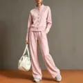 Gedetailleerd overzicht van het roze dames trainingspak met opstaande kraag en wijde broek. - S / Top en Broek / Roze