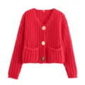 Detail van rood grof gebreid vest met gouden knopen, V-hals en zakken aan de voorkant. - S / Rood