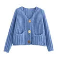 Detail van het blauwe gebreid vest met V-hals, unieke breitextuur en gouden knopen. - S / Blauw