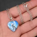 Close-up detail of the silver-tone heart pendant necklace featuring a howling wolf design. - Wolf Head Style (AA356)