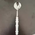 Stainless steel round soup spoon with white beaded handle, perfect for home and student dining. - Round Spoon / White