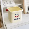 Small cream desktop trash can with cute smiley face design for office and room storage use. - S / Cream