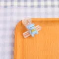 Clip per raccoglitore in plastica trasparente con simpatico orsetto blu e fiocco giallo. - Orso Blu