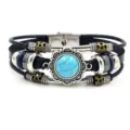 Close-up detail van de vintage turquoise meerlaagse lederen armband met metalen bedels. - Groen