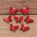 Detail shot of red acrylic butterfly charms with gold loops for DIY jewelry making crafts. - Red