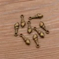 Closeup of vintage bronze conch screw pendants, zinc alloy DIY jewelry making findings parts. - Antique Bronze