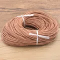 Gros plan détaillé d'un cordon en cuir de vache rond marron clair, enroulé pour le bricolage. - 1.0mm / Naturel