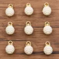 Détail en gros plan du charm perle d'imitation DIY avec anneau strass et boucle or. - Blanc