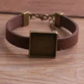 Detailopname van retro bruin PU lederen armband met vintage bronzen vierkante bezel zetting. - Bruin