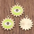 Detailed close-up view of round evil eye metal enamel pendant, DIY jewelry charm. - Green