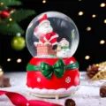 Weihnachts-Schneekugel Spieluhr mit Weihnachtsmann, rotem Sockel und grüner Schleife Geschenk. - Groß 100 Schnee+Licht+Musik / 2021 Schneemann