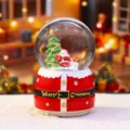 Nahaufnahme der Weihnachtskugel mit Weihnachtsmannfigur im Detail und beleuchtetem Sockel. - 2041 Weihnachtsmann mit Geschenkanhänger / Groß 100 Schnee+Licht+Musik