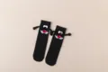 Black mid-tube socks with funny magnetic holding hands design, cute and creative casual wear. - Style A