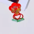 Detailed close-up view of Christmas hair ties with red bands and green festive charms. - Christmas Letter Sign Hair Tie Pair