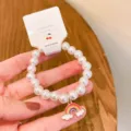 Close-up detail of cute Korean style pearl beaded bracelet with colorful rainbow charm. - Rainbow